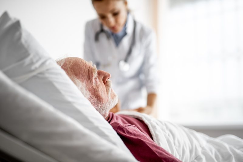Älterer Mann liegt im Krankenbett